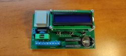 Two-channel timer programmer on a table, with an LCD display and electronic components.