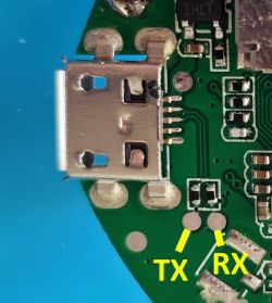 Close-up view of a PCB with a micro USB port and labeled TX and RX pads.