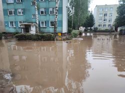 Zalane osiedle z powodu powodzi z wodą stojącą na dziedzińcu pomiędzy budynkami mieszkalnymi.