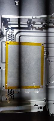 Wnętrze obudowy konsoli Xbox 360 slim z zamontowaną płytą na dolnej części.