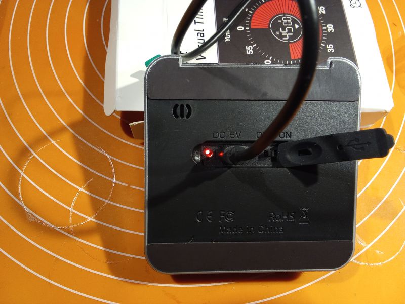 Widok z tyłu elektronicznego minutnika z podłączonym kablem do ładowania.