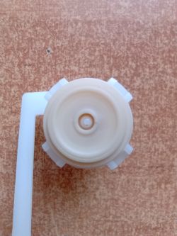 Inter-Sano Fill Valve Membrane Repair with Silicone Adhesive Close-up of an Inter-Sano fill valve membrane glued with clear silicone adhesive and clamped with a LUX-TOOLS spring clamp using a 1 zł coin.