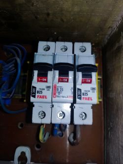 Zbliżenie na trzy wyłączniki nadprądowe FAEL w panelu elektrycznym.