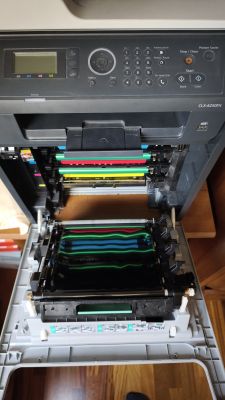 Otwarta drukarka Samsung CLX-6250FX z widocznymi bębnami i kolorowymi wałkami.