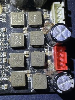 Zbliżenie na płytkę drukowaną z uszkodzonymi kondensatorami w soundbarze Creative Sound Blaster X Katana.