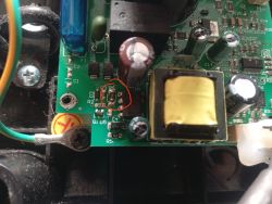 Zbliżenie na płytkę PCB z transformatorem i czerwonym kółkiem zaznaczającym rezystor