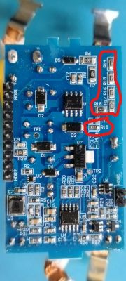 Blue printed circuit board with various electronic components, including resistors marked in red.