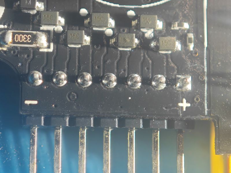 Zbliżenie na płytkę PCB z elementami SMD „15C/16C” i rezystorem „3300” przy złączu pinowym.