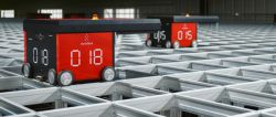 Two red AutoStore robots moving on a metal warehouse grid system