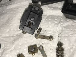 Disassembled Drill Switch Components Switch components, including springs and metal elements, on a paper towel.