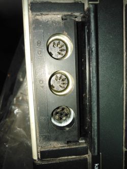 Zbliżenie na trzy gniazda DIN w urządzeniu elektronicznym.