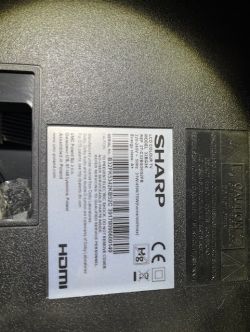 Label on a Sharp TV with model and connection information.