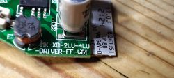 Close-up of a green circuit board with electronic components and markings.