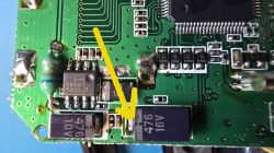 Close-up of a PCB with SMD parts; yellow arrow points to a solder point near a 470 µF capacitor