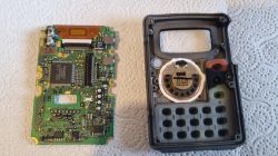Płytka PCB i wnętrze obudowy ręcznego radiotelefonu z głośnikiem i klawiaturą na białym podkładzie