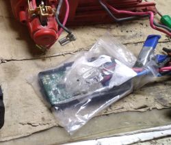 Płytka elektroniki z przewodami w woreczku strunowym na brudnym blacie warsztatowym