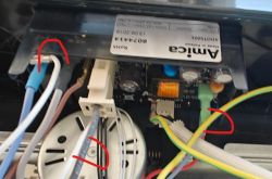 Zdjęcie wnętrza urządzenia elektronicznego z widocznymi kablami i podzespołami.