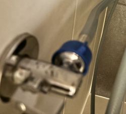 Zbliżenie na zawór wodny z założonym niebieskim plastikowym korkiem