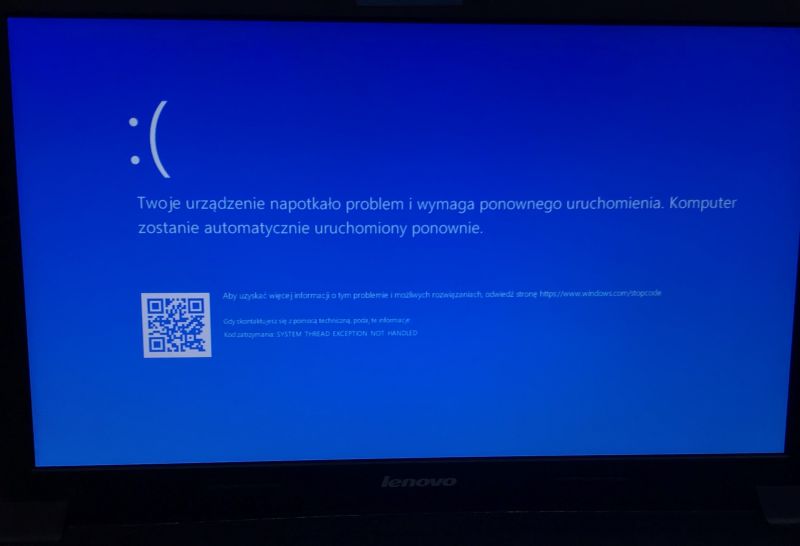 Windows blue screen error with restart message and QR code shown on a Lenovo laptop screen.