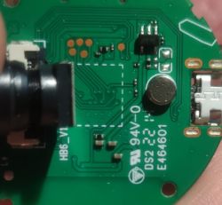Close-up of a green circuit board showing a camera lens, microphone, and micro USB port.