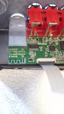 Nahaufnahme einer Leiterplatte mit roten Anschlüssen und elektronischen Bauteilen.