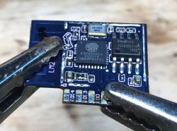 ESP8266EX WiFi Module After Flooding WiFi module ESP8266EX held in pliers.