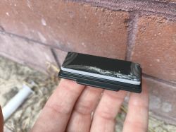 Electronic Module Against a Brick Wall Flat electronic module held in a hand against a brick wall.