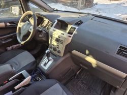 Car interior: dashboard, Opel steering wheel, center console, and automatic gear shifter.