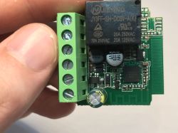 Relay module with screw connector and SMD components Electronic circuit board with relay and screw terminal block in close-up