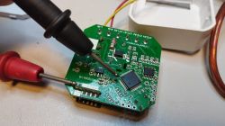 Close-up of a circuit board with a probe touching one of its components.