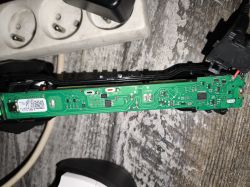 Widok płytki drukowanej z komponentami elektronicznymi, z białym złączem po lewej stronie.