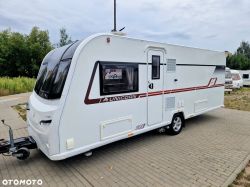 White Unicorn camper trailer parked on a paved surface.