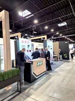 F&amp;F trade show booth with a counter and several men in suits in an exhibition hall.