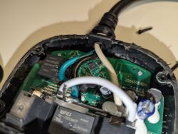 Interior of dismantled electronic device with visible PCB and wires