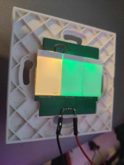 Electronic switch with connected wires and colored backlighting.