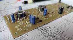 Płytka drukowana z zamontowanymi elementami elektronicznymi, widoczne cewki i kondensatory elektrolityczne.