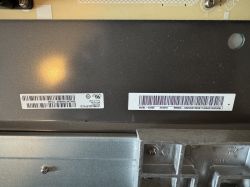 Barcode Stickers on Device Casing Two stickers with barcodes and serial numbers on the metal casing of an electronic device.