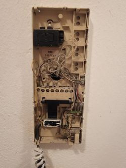 Interior of a door phone device with exposed wiring and numbered terminals.