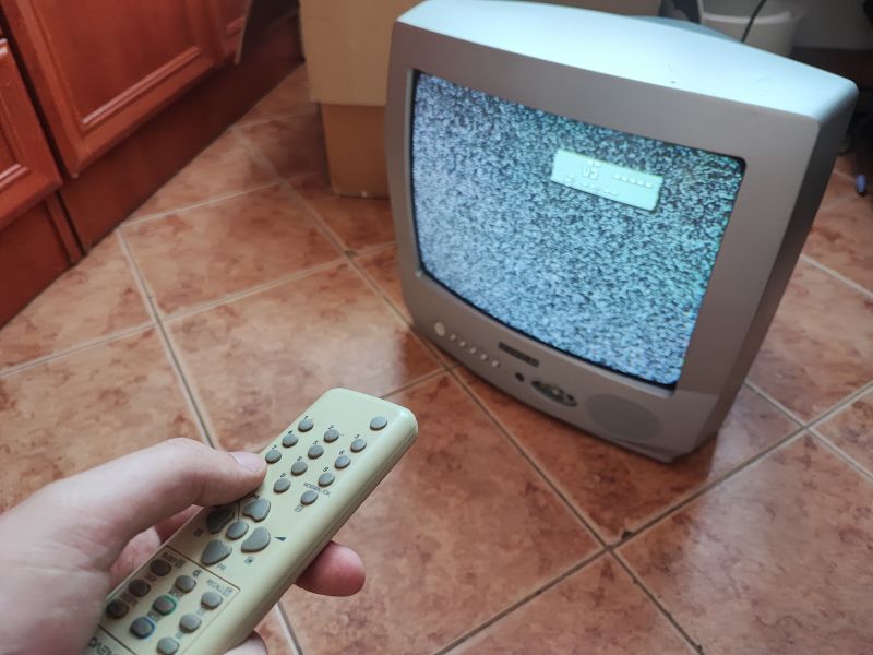 Telewizor kineskopowy Daewoo K14C5GT z pilotem, wyświetlający zakłócenia na ekranie.