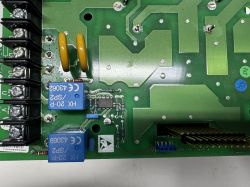 Płytka drukowana z falownika ze zbliżeniem na elementy elektroniczne, w tym przekaźniki.