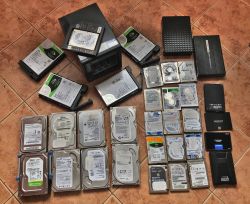 Zbiór różnych dysków twardych i SSD rozłożonych na podłodze
