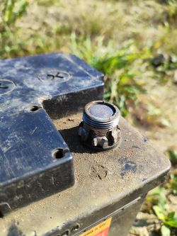 Zbliżenie na stary akumulator z metalowym złączem.