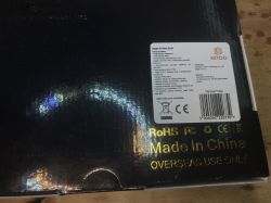 Czarna błyszcząca część opakowania przystawki TV Box z naklejką zawierającą specyfikację techniczną i napisem „Made in China”.
