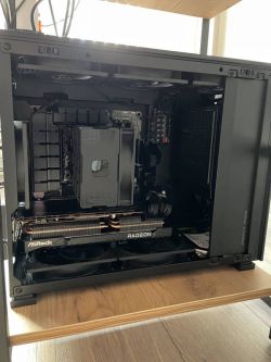 Widok wnętrza obudowy komputera z zamontowaną kartą graficzną Radeon i wentylatorami.