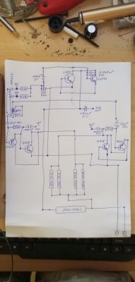 Schemat elektroniczny na kartce papieru otoczony narzędziami do lutowania.