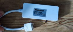 Energizer Adapter for Smart LED Strip Light White Energizer adapter with a plug for model S17164, Smart 5m LED Strip Light, on a wooden background.