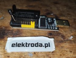 Close-up of a CH341 USB to UART converter on a wooden surface.