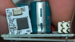 CBL C5 Module on Circuit Board Close-up of a circuit board with a CBL C5 module and a capacitor against a background of fingers.