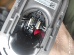 Zdjęcie wnętrza urządzenia elektrycznego z widocznymi stykami i czerwonym elementem.
