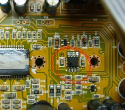 The image shows a circuit board with various electronic components, with a highlighted integrated circuit circled in red.